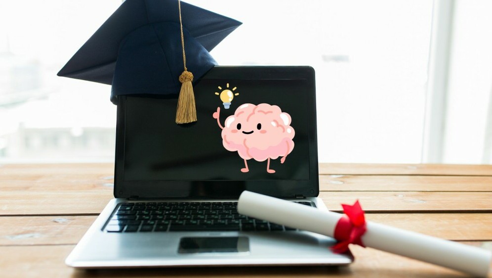 Laptop s diplomom i kapom uz grafiku mozga