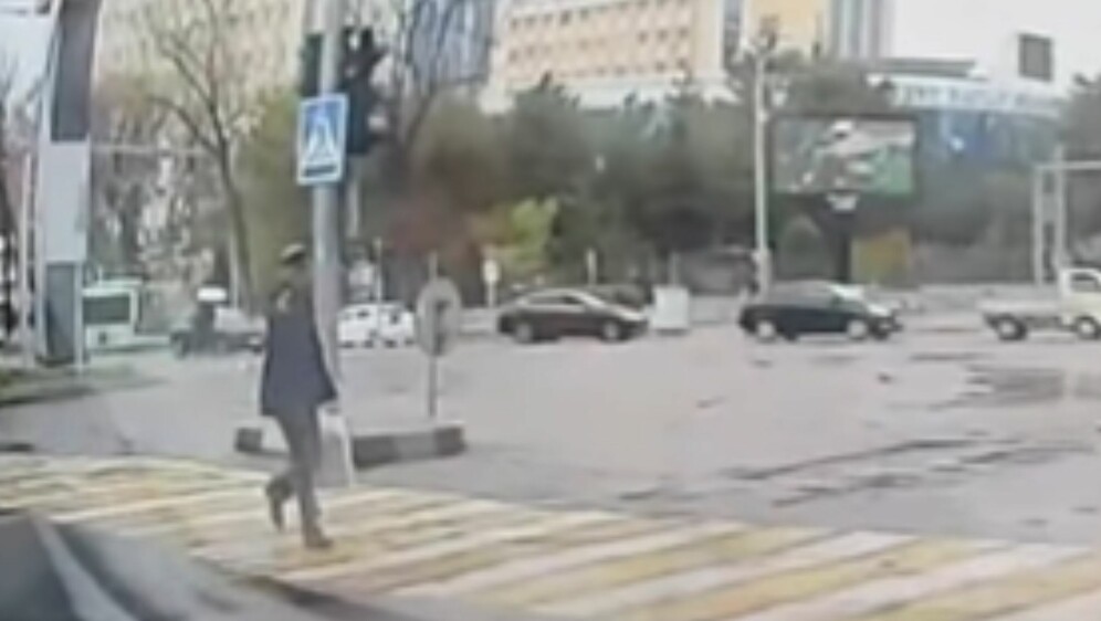 Starac koji prelazi cestu s pištoljem u ruci