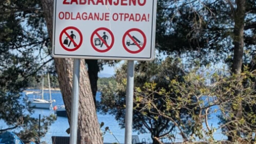 Deponij ispod znaka za zabranu odlaganja otpada