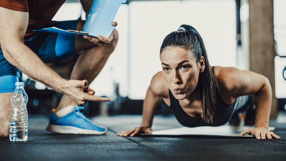 Žena koja radi sklekove u teretani