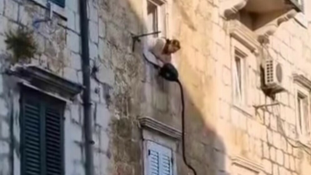 Žena pokušava dohvatiti rublje