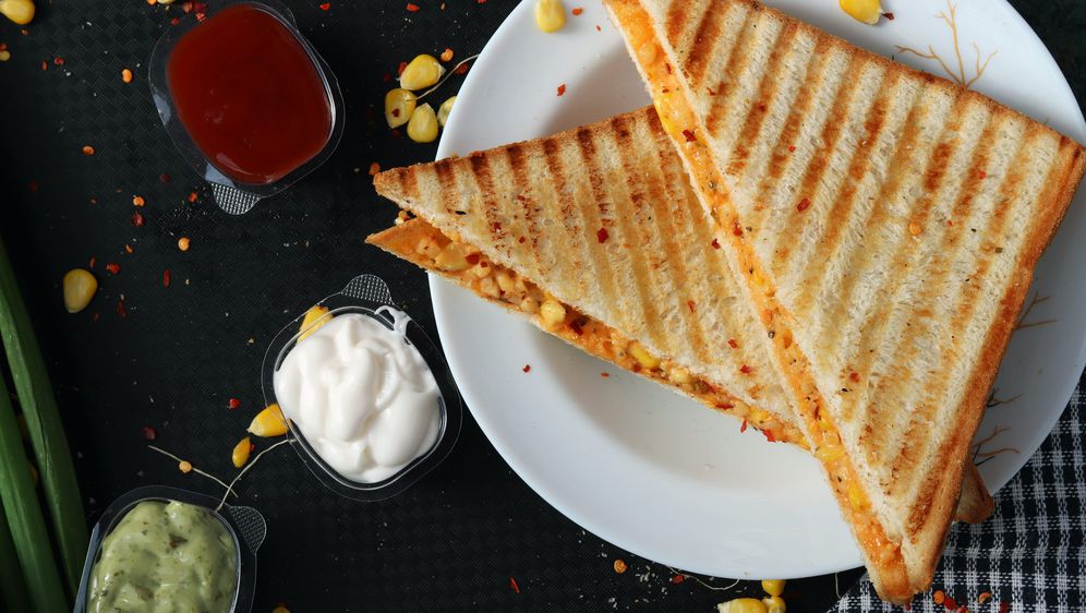 sendvič prerezan na pola na stolu uz umake