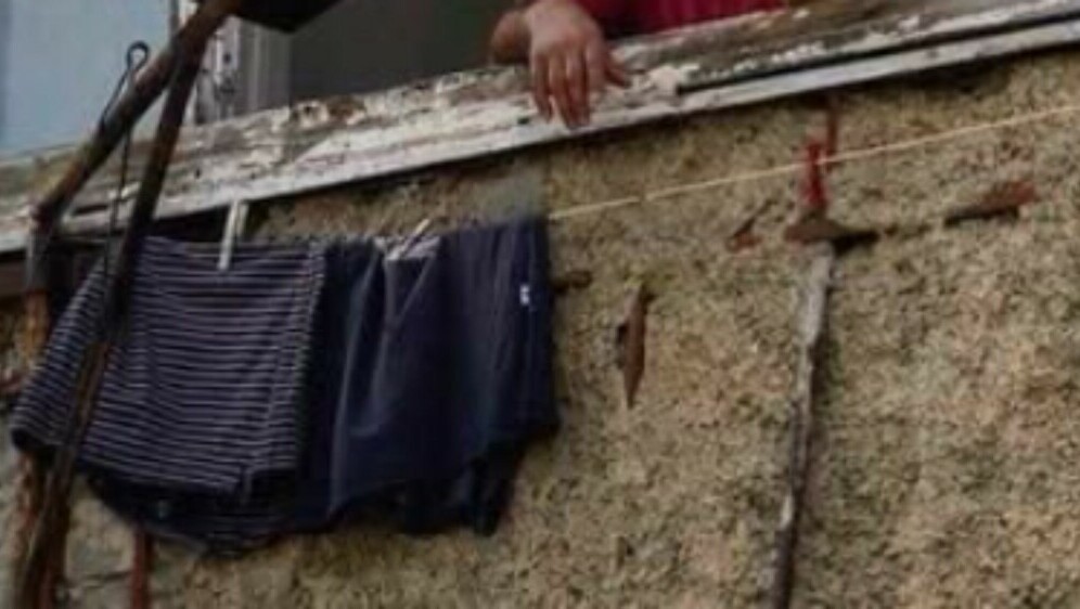 Muškarac na prozoru kako peče roštilj