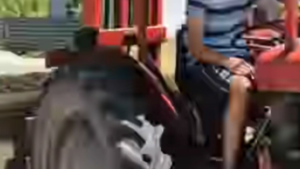 Mladić na traktoru koji prevozi kauč