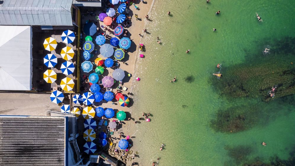 Plaža s kupačima i suncobranima