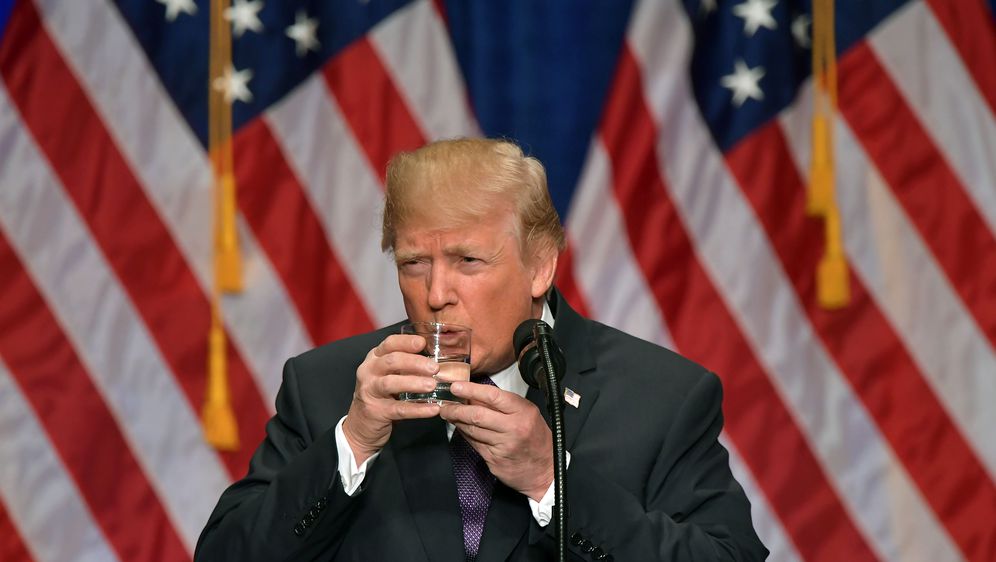 Donald Trump drži čašu s dvije ruke poput malog djeteta (Foto: AFP)