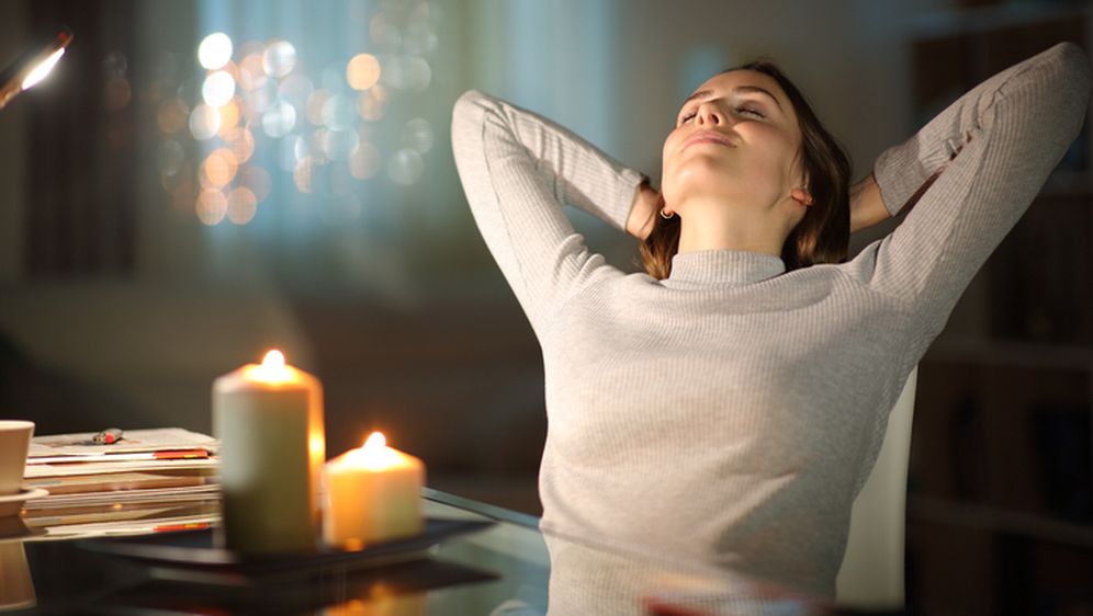 Žena se opušta uz ugodnu atmosferu i zapaljene mirisne svijeće, ilustracija