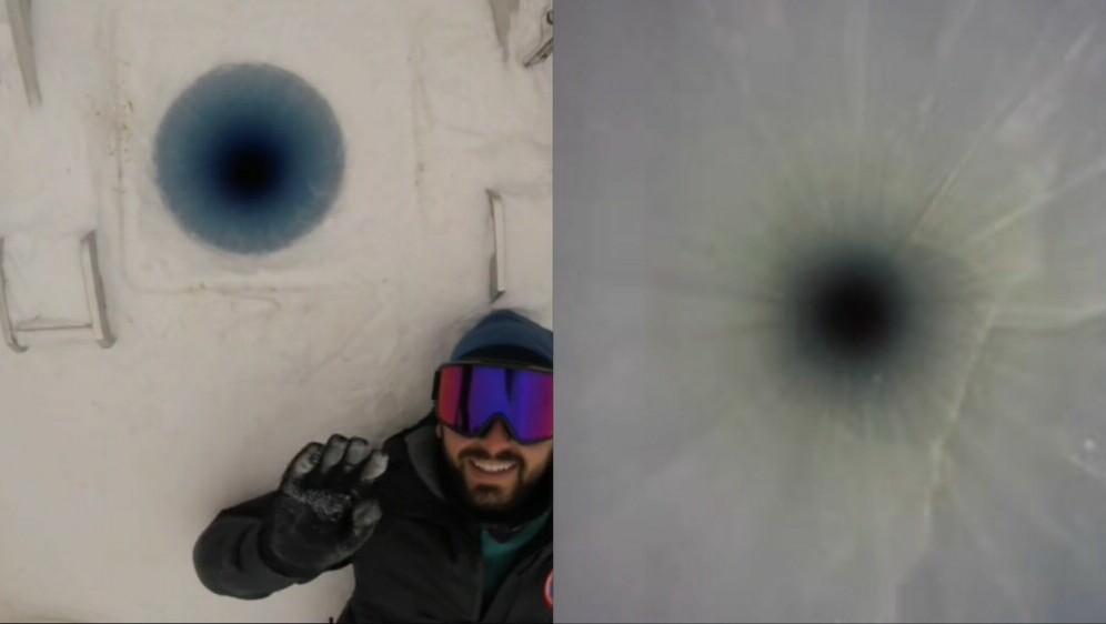 Znanstvenik Austin Carter kako spušta kameru niz rupu u ledu