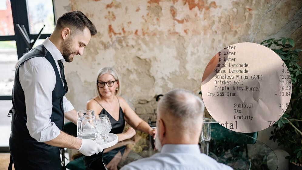 Konobar kako poslužuje ljude i račun iz restorana
