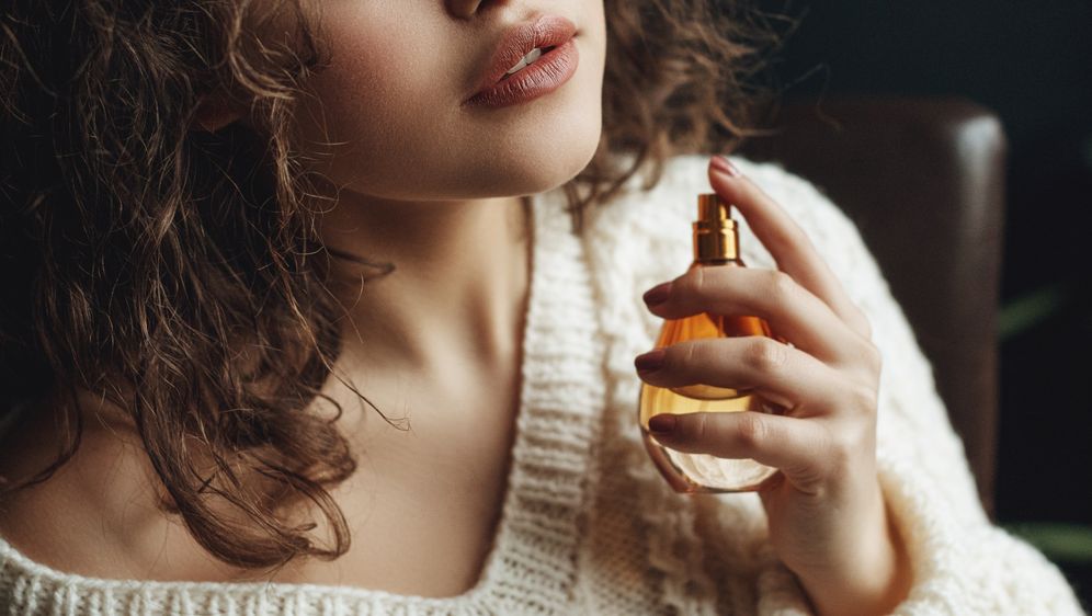 Žena i bočica parfema