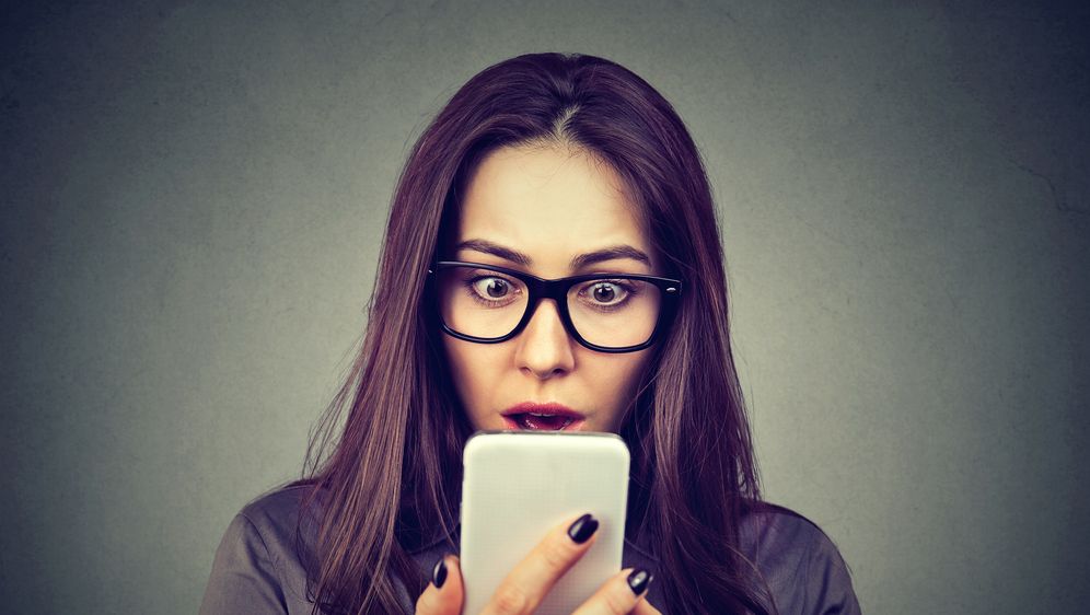 Šokirana žena gleda u telefon, ilustracija