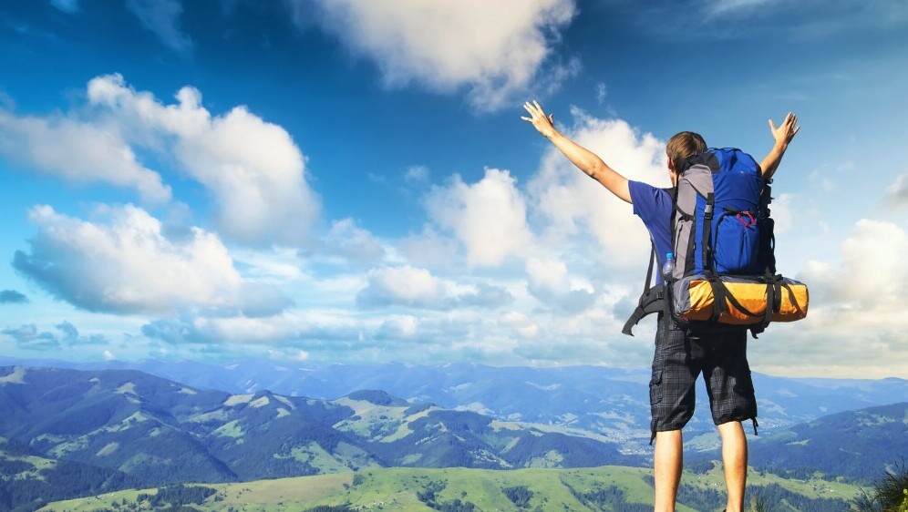 Muškarac s raširenim rukama kako gleda prema horizontu