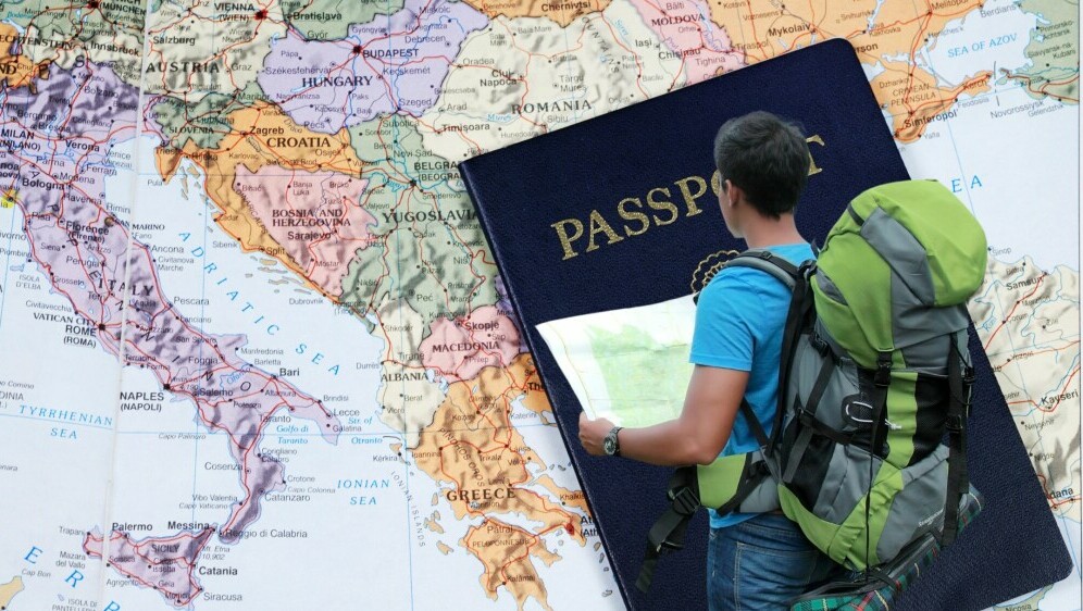 Karta Europe i turist s kartom u rukama i ruksakom na leđima