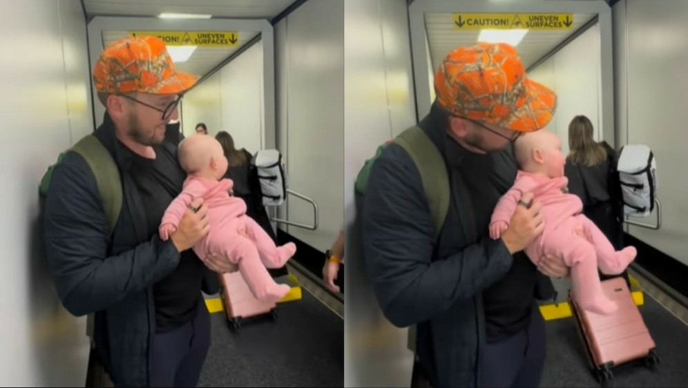 Otac koji drži bebu u rukama nakon izlaska iz zrakoplova