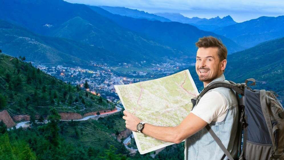 Grad u planinama i turist s ruksakom i kartom