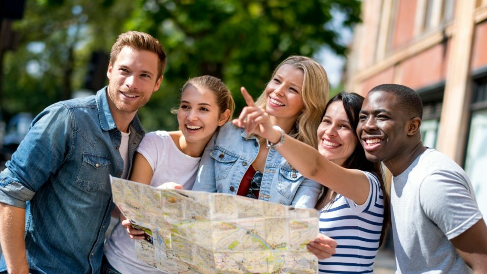 Razni turisti koji gledaju na kartu