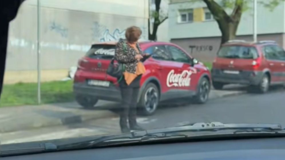 Gospođa na mobitelu nasred pješačkog prijelaza