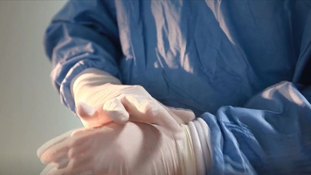 Liječnik stavlja jednokratne rukavice