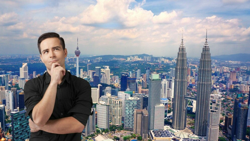 Muškarac koji razmišlja ispred panoramskog prikaza grada