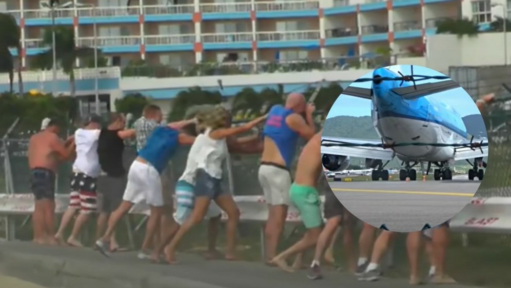 Mlažnjak pri polijetanju i turisti koji se drže za ogradu