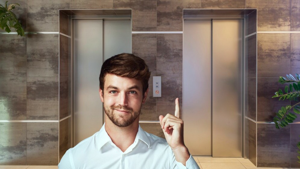 Dizalo u zgradi i muškarac koji pokazuje prema gore