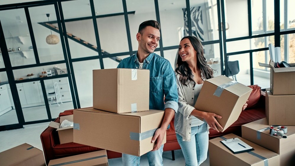 Par koji se seli s kutijama u rukama