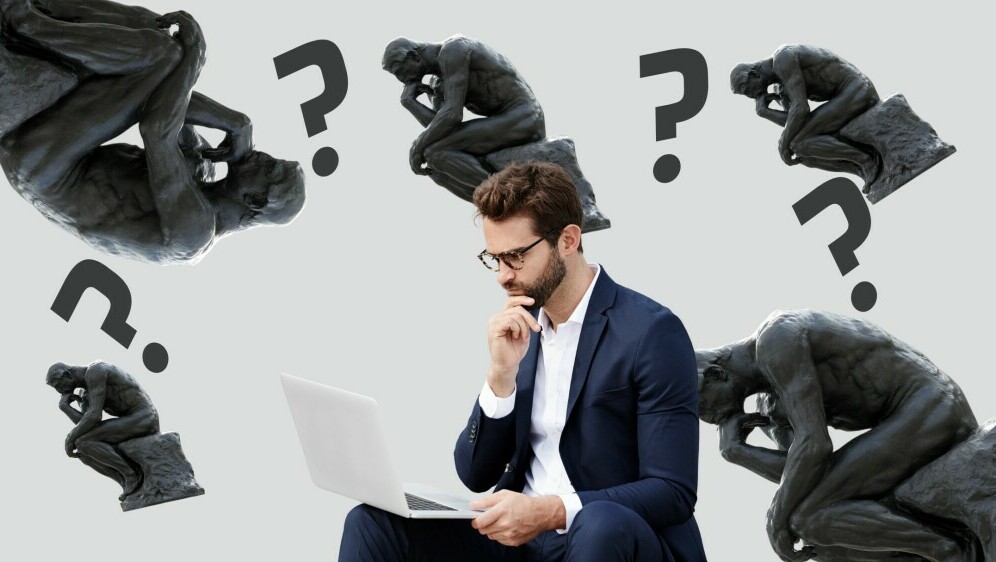 Muškarac koji razmišlja pred računalom i kip mislioca