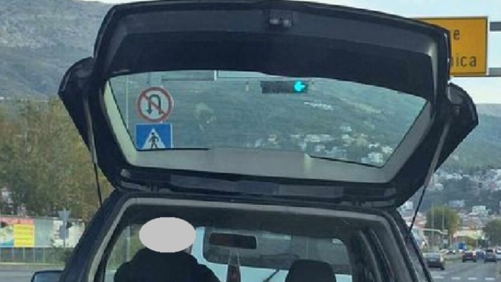 Vozač koji rukom pridržava teret koji prevozi