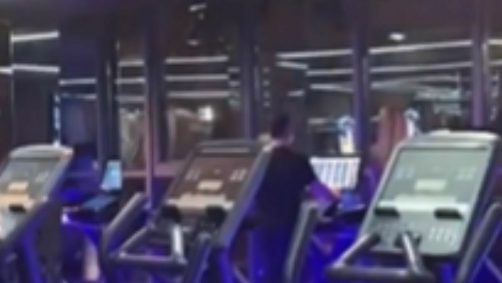 Muškarac u teretani na traci za trčanje