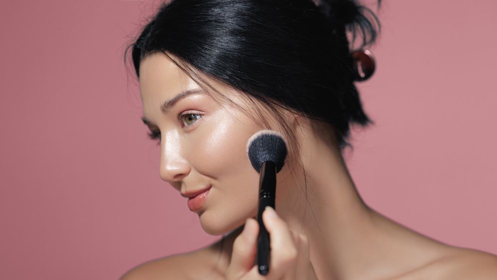 Žena nanosi puder kistom