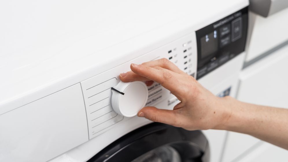 Žena namješta perilicu rublja