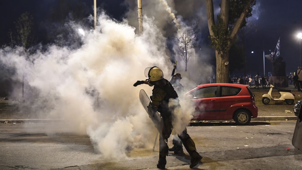 Grčki policajac baca suzavac (Foto: AFP)