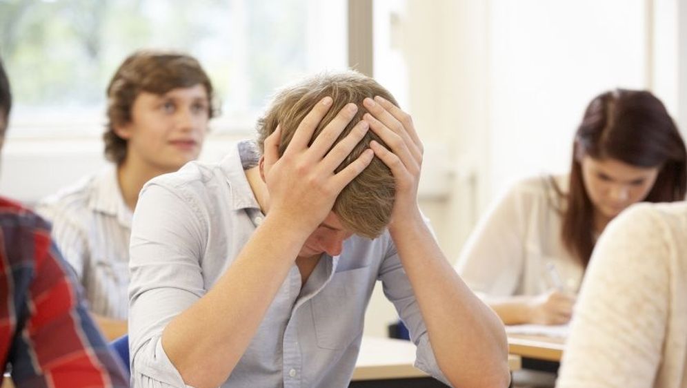 Dečko se drži za glavu