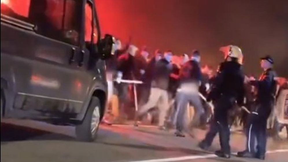 Huligani s palicama prolaze pokraj policije