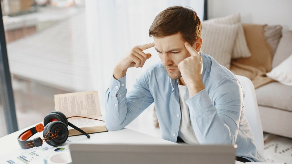 Muškarac za računalom kako razmišlja