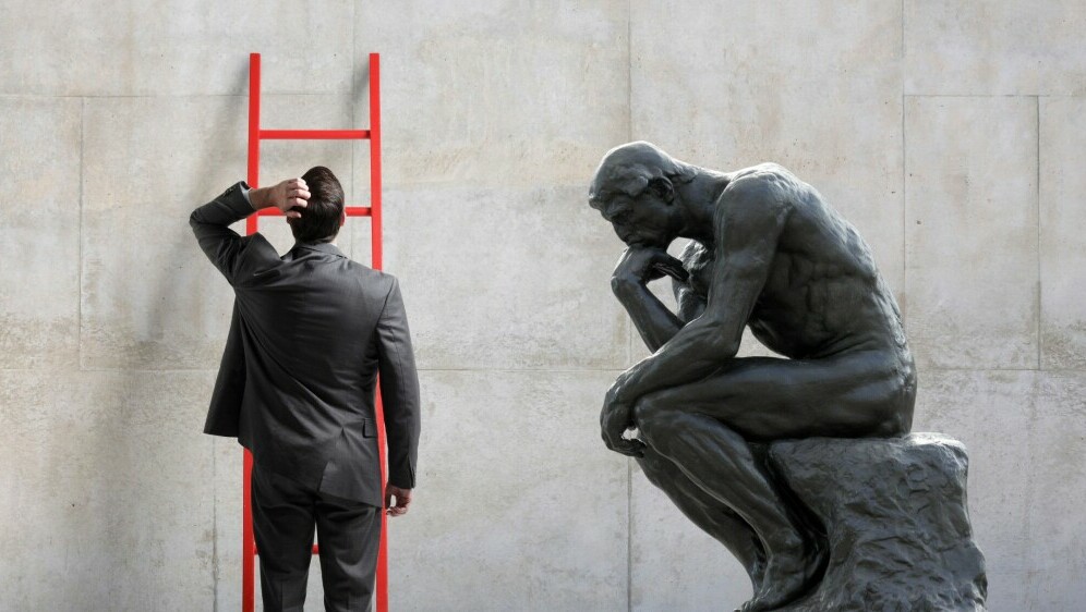 Muškarac ispred ljestvi i mislilac