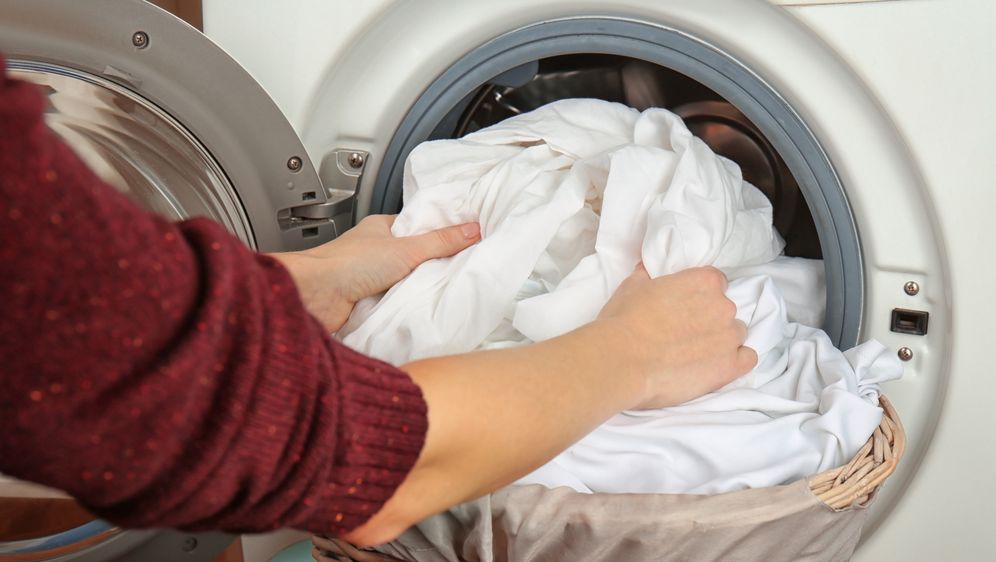 Žena vadi oprano rublje iz perilice