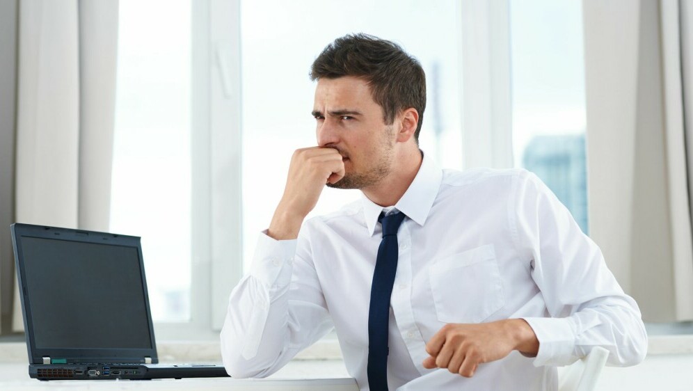 Muškarac koji razmišlja pred računalom